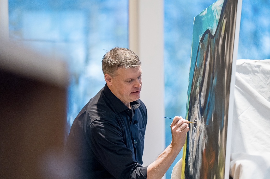 Sam painting the eye of a wolf during a live keynote